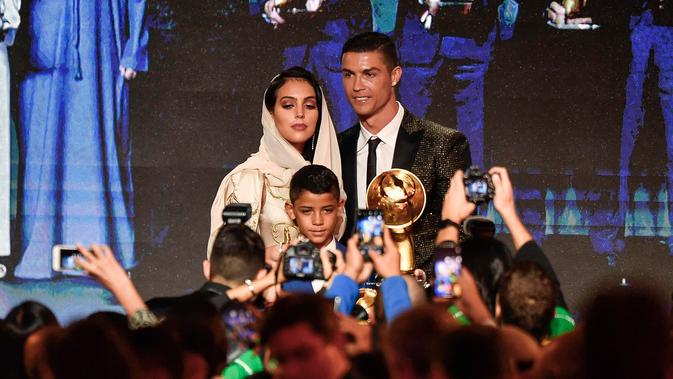 Georgina Rodriguez foto bersama dengan kekasihnya Cristiano Ronaldo dan putranya Cristiano Jr diatas panggung selama Dubai Globe Soccer Awards ke-10 di Dubai (3/1). (AFP Photo/Fabio Ferrari)