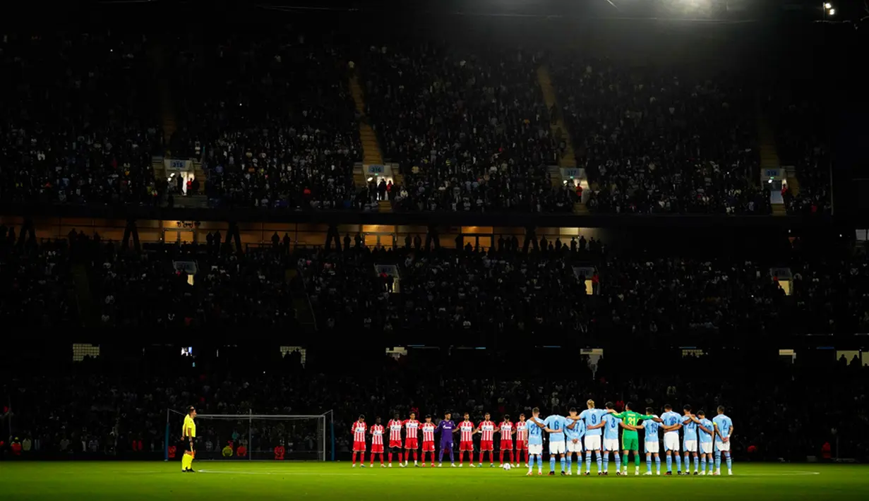 Pemain Manchester City (kanan) dan Red Star Belgrade berdiri saat mengheningkan cipta untuk mengenang para korban banjir Libya dan gempa Maroko sebelum pertandingan sepak bola Grup G Liga Champions antara Manchester City dan di Manchester, Inggris, Selasa (19/9/2023). Banjir Libya menewaskan lebih dari 11.000 orang dan 10.100 lainnya hilang, sementara gempa Maroko menewaskan setidaknya 2.900 orang. (AP Photo/Dave Thompson)