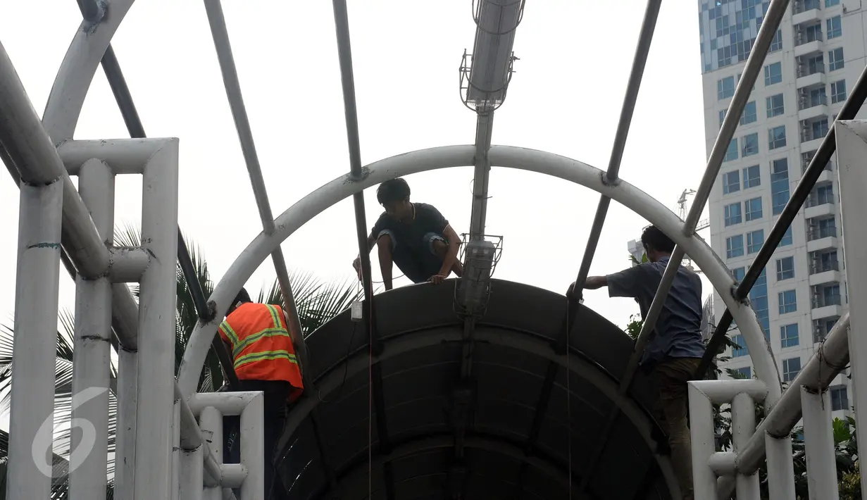 Pekerja melakukan penggantian atap Jembatan Penyebrangan Orang (JPO) di Jalan Kasblanca, Jakarta, Selasa (22/11). Pemerintah Provinsi DKI Jakarta menargetkan perbaikan JPO tak layak segera rampung. (Liputan6.com/Helmi Fithriansyah)
