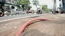 Kendaraan melintasi kabel proyek PLN yang terbengkalai di Jalan Jatinegara Kaum, Jakarta, Minggu (12/1/2020). Kurangnya pengawasan dalam penyelesaian proyek instalasi listrik bawah tanah PLN tersebut menyebabkan banyak kabel masih muncul di trotoar dan bahu jalan. (merdeka.com/Iqbal S. Nugroho)