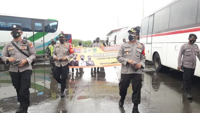 Aparat kepolisian memberikan masker gratis dan edukasi secara masif kepada para penumpang di pool bus Sinar Jaya, Jalan Inspeksi Kalimalang, Desa Suka Danau, Cikarang Barat, Kabupaten Bekasi, Jawa Barat.
