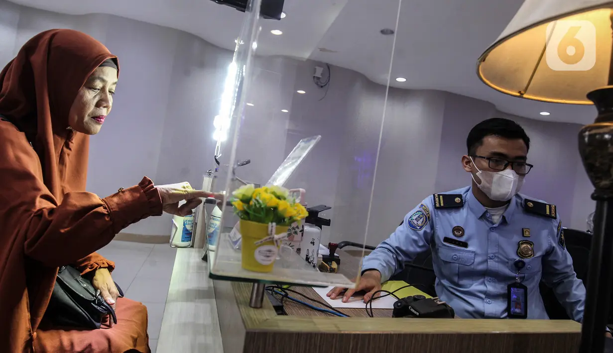 Petugas melakukan perekaman data pemohon pembuatan paspor Republik Indonesia (RI) di Kantor Imigrasi Kelas 1 Non TPI Jakarta Timur, Jakarta, Jumat (14/10/2022). Sesuai Peraturan Menteri Hukum dan HAM RI Nomor 18/2022 mulai 12 Oktober 2022 masa berlaku paspor biasa paling lama 10 tahun untuk semua jenis permohonan yang telah berusia 17 tahun atau sudah menikah. (Liputan6.com/Johan Tallo)