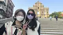 Turis Beijing Xylia Zhang (kanan) dan Charline Zeng berpose saat mereka mengunjungi Makau untuk perjalanan lima hari di Makau pada 28 Desember 2022. Zhang, melakukan perjalanan pertamanya ke luar daratan sejak pandemi dimulai, menantikan untuk mencoba peruntungannya di kasino. (AP Photo/Kanis Leung)