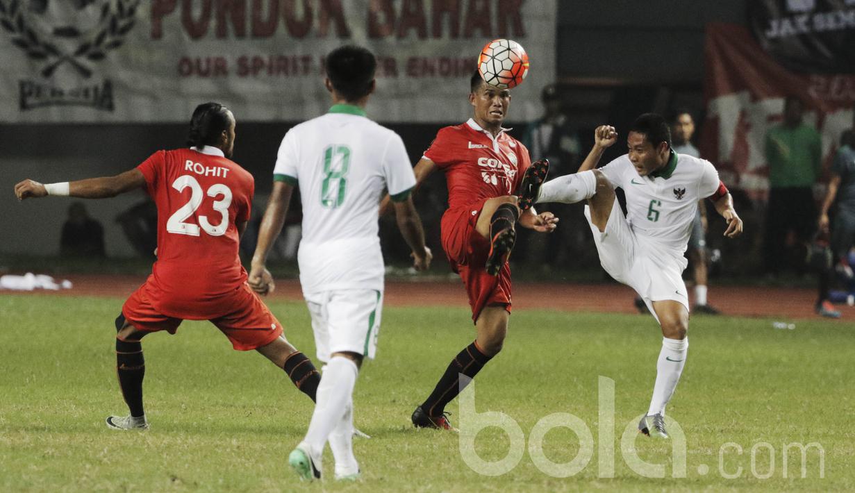 Gelandang Timnas Indonesia U-22, Evan Dimas, berebut bola dengan gelandang Persija, Sandi Sute. Meski hanya uji coba kedua tim tetap bermain serius dan saling jual beli serangan selama 90 menit. (Bola/ M Iqbal Ichsan)