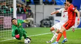 Pemain Timnas Indonesia, Mees Hilgers (tengah) berusaha mencetak gol ke gawang China yang dijaga oleh Wang Dalei saat laga lanjutan putaran ketiga Grup C Kualifikasi Piala Dunia 2026 di Qingdao Youth Stadium, Qingdao, China, Selasa (15/10/2024). (AFP)