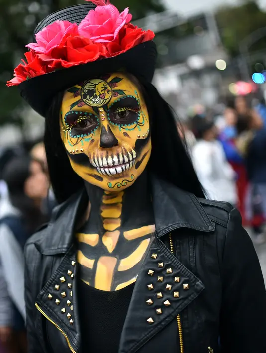 Seorang wanita berpakaian seperti "Catrina" ambil bagian dalam parade Hari Orang Mati di Reforma Avenue, Mexico City, 21 Oktober 2018. Hari kematian ini jadi hari libur nasional di negara-negara Amerika Latin, khususnya Meksiko. (RODRIGO ARANGUA/AFP)