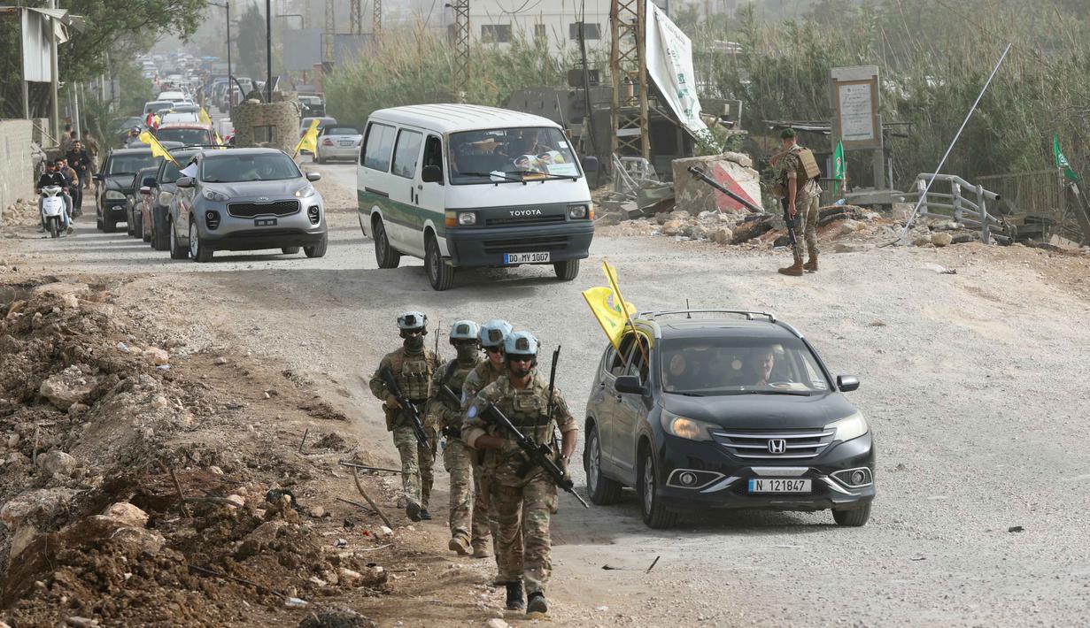 Kesepakatan ini menjadi fase awal untuk meredakan ketegangan antara kelompok Hizbullah dan Israel. Tampak dalam foto, Kontingen Prancis dari Pasukan Sementara Perserikatan Bangsa-Bangsa di Lebanon (UNIFIL) berpatroli di daerah tersebut sementara warga yang mengungsi sambil mengibarkan bendera Hizbullah kembali ke rumah mereka melalui jalan darurat yang dibangun di lokasi jembatan Qasmieh yang hancur akibat serangan Israel, di wilayah Al-Qasmiyeh, Lebanon Selatan, pada Sabtu 18 April 2026. (MAHMOUD ZAYYAT/AFP)