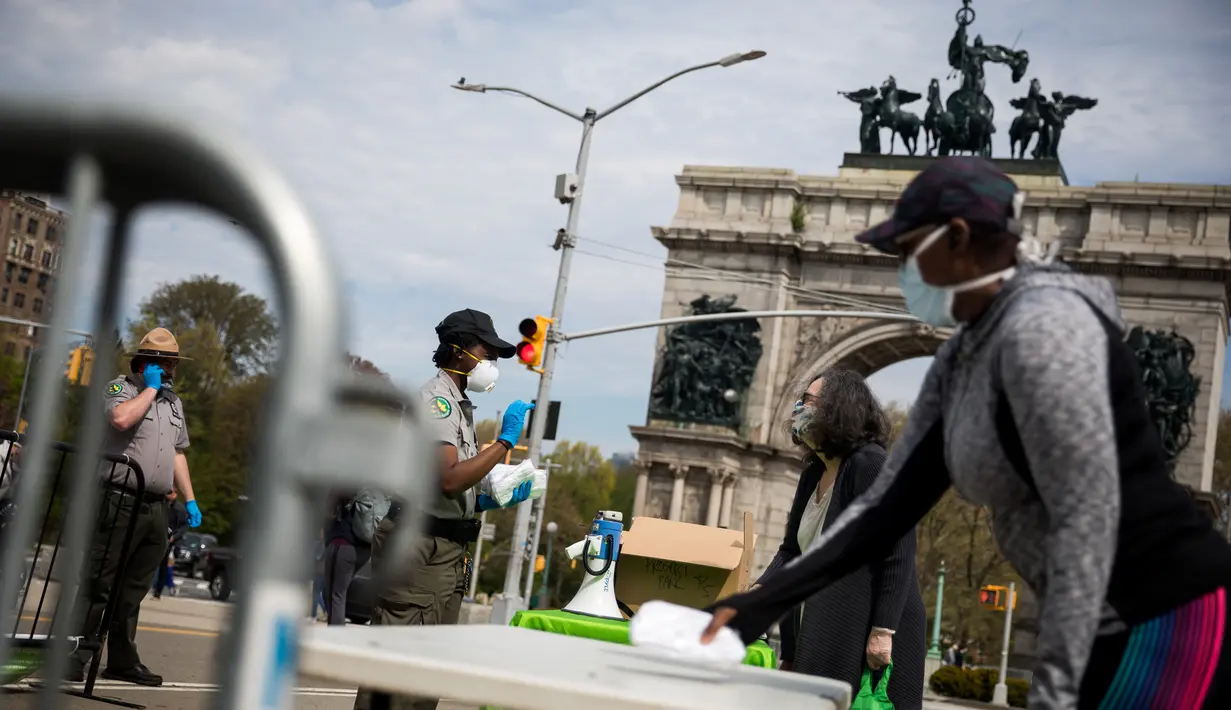 Petugas jagawana taman kota New York City membagikan masker gratis di Prospect Park di wilayah Brooklyn di New York, AS (3/5/2020). New York City (NYC) akan membagikan lebih dari 100.000 penutup wajah secara gratis di taman-taman di seluruh kota itu mulai 2 hingga 5 Mei. (Xinhua/Michael Nagle)