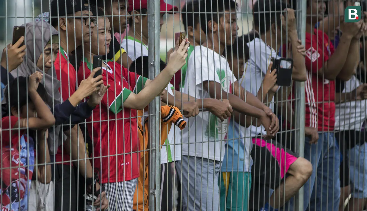 Sejumlah warga menonton latihan Timnas Indonesia di Lapangan ABC Senayan, Jakarta, Minggu (18/3/2018). Latihan ini merupakan persiapan jelang laga uji coba melawan Singapura. (Bola.com/Vitalis Yogi Trisna)