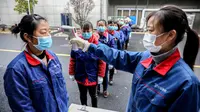 Karyawan diukur suhu badannya di sebuah perusahaan di Changxing, Huzhou, Provinsi Zhejiang, China, Rabu (12/2/2020). Di bawah arahan dan dukungan otoritas setempat, banyak perusahaan di Zhejiang kembali beroperasi setelah melakukan pencegahan dan pengendalian wabah virus corona. (Xinhua/Xu Yu)