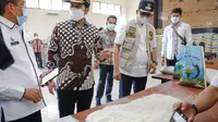 Wagub Jatim Emil Dardak mengecek beras bansos di Bangkalan. (Dian Kurniawan/Liputan6.com)