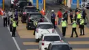Petugas mengarahkan kendaraan berplat genap berputar balik di Gerbang Tol Bekasi Barat 1, Bekasi, Jawa Barat, Selasa (13/3). Hari kedua penerapan ganjil genap, masih banyak kendaraan berputar balik di gerbang tol tersebut. (Liputan6.com/Arya Manggala)