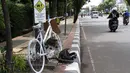 Monumen sepeda putih atau ghost bike bersandar di sebuah tiang kawasan Jenderal Gatot Subroto, Jakarta, Senin (12/3). Monumen itu untuk mengenang pesepeda Raden Sandy Syafiek yang tewas tertabrak mobil. (Liputan6.com/Immanuel Antonius)