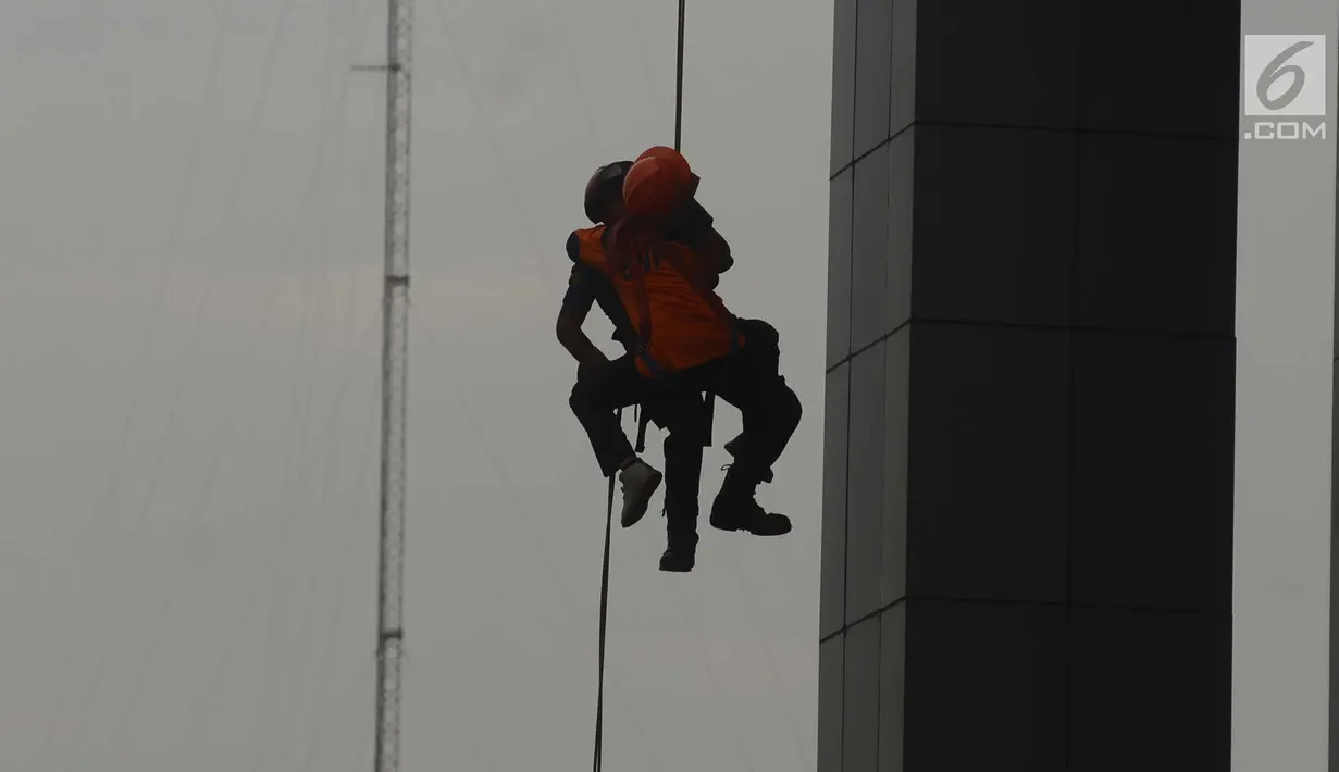 Petugas BNPB menyelamatkan korban dalam simulasi penaggulangan bencana di Gedung BNPB, Jakarta, Selasa (24/4). Simulasi ini melatih kesiapan menjelang peringatan apel Hari Kesiapsiagaan Bencana (HKB) pada Kamis, 26 April 2018. (Merdeka.com/Imam Buhori)