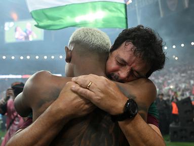 Pemain Fluminense, John Kennedy berpelukan dengan pelatih Fernando Diniz saat merayakan kemenangan atas Boca Juniors pada final Copa Libertadores yang berlangsung di Maracana Stadium , Rio de Janeiro, Brasil, 5 November 2023 WIB. (AFP/Carl De Souza)