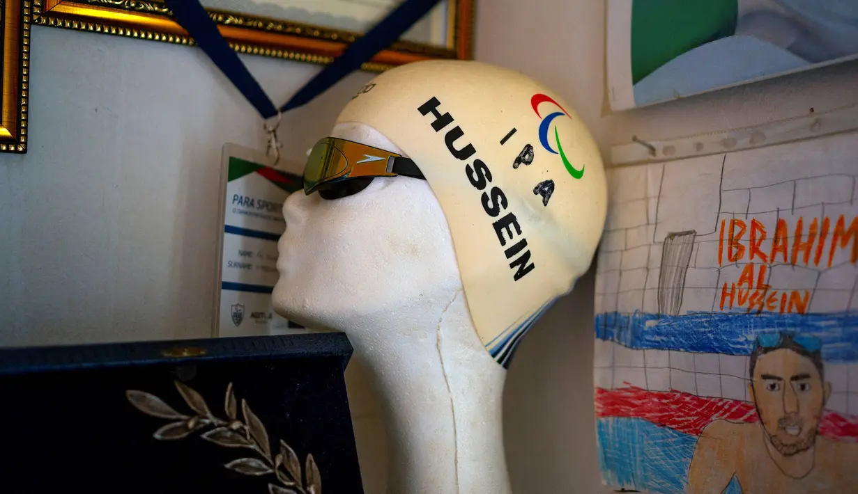 Selain medali dan penghargaan, topi renang al-Hussein menjadi barang bersejarah yang mengingatkan debutnya bersama tim pengungsi pertama di Olimpiade Rio 2016. Ia juga dipercaya membawa bendera timnya menuju Stadion Maracana yang bersejarah. (Foto: AFP/Angelos Tzortzinis)