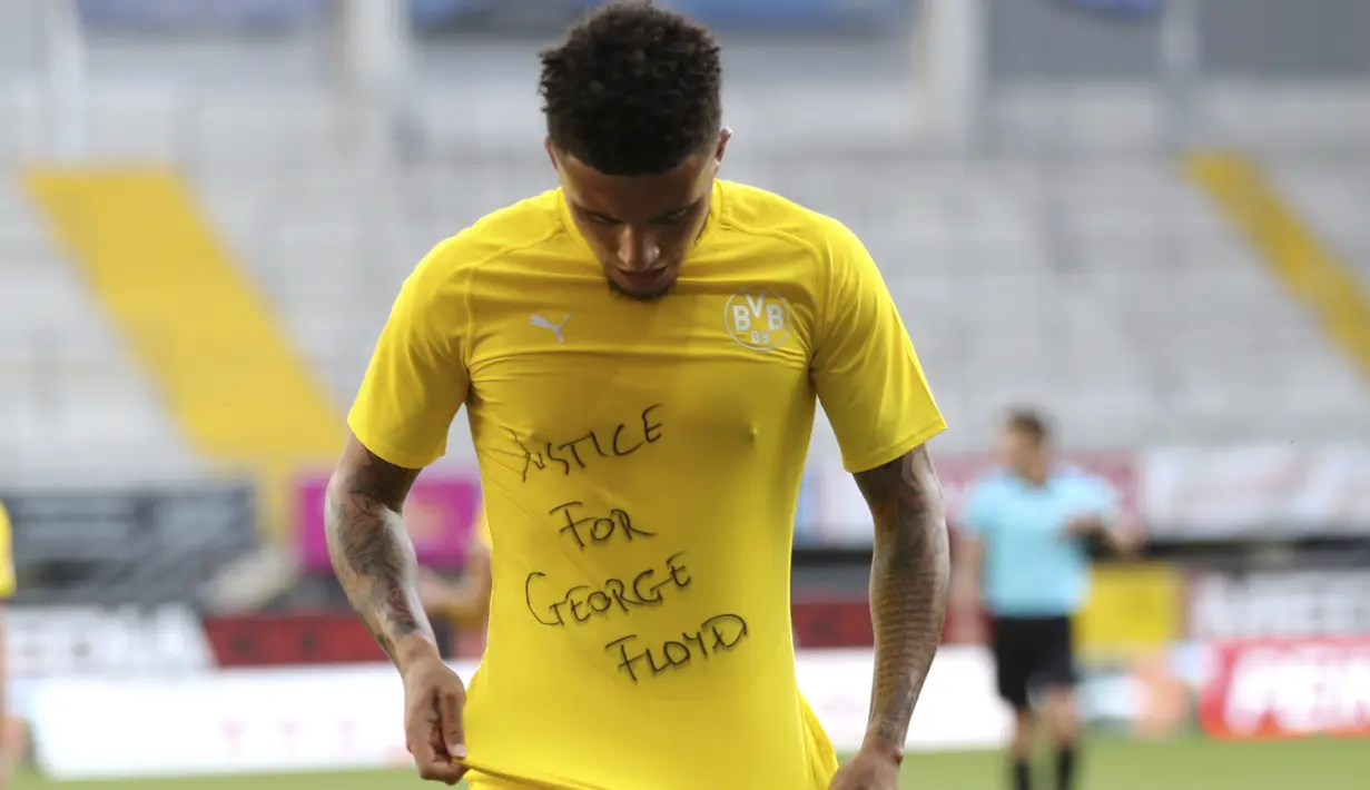 Pemain Borussia Dortmund, Jadon Sancho, menunjukan tulisan rasa simpati untuk mendiang George Floyd saat melawan SC Paderborn 07 pada laga Bundesliga di Stadion Benteler, Minggu (31/5/2020). Borussia Dortmund menang dengan skor 6-1 SC Paderborn 07. (AP/Lars Baron)