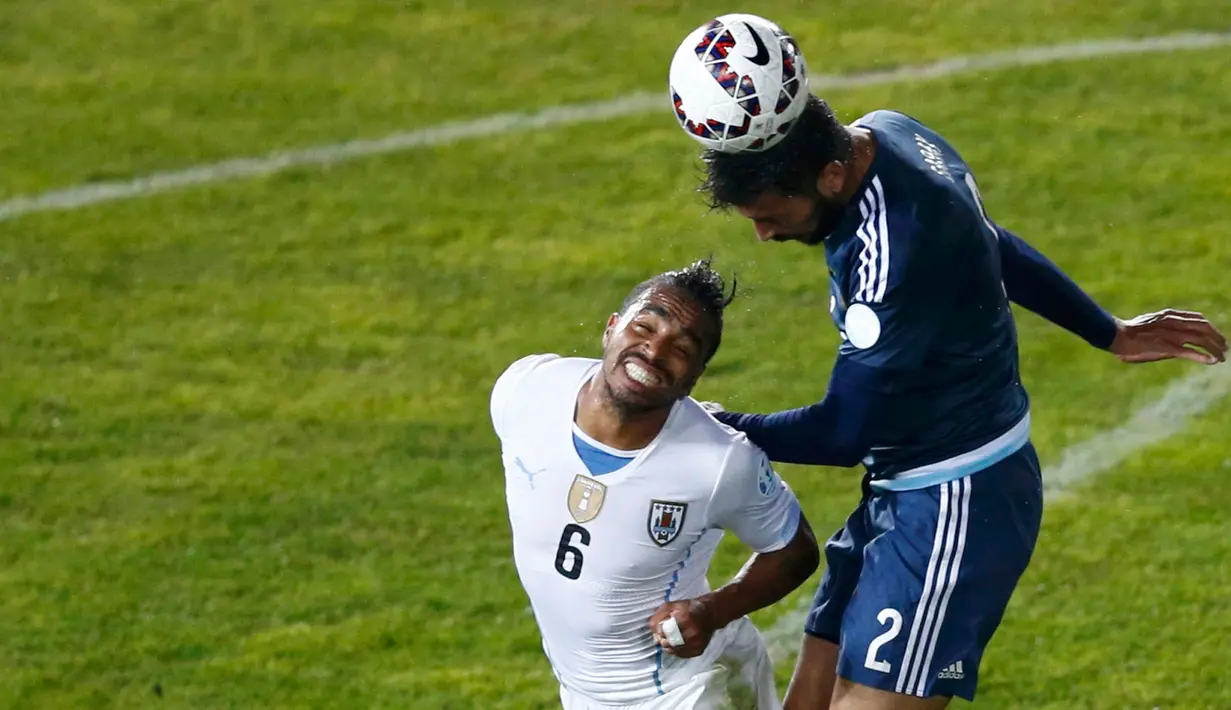Gelandang Uruguay, Alvaro Pereira berebut bola udara dengan bek Argentina Ezequiel Garay saat pertandingan Copa America 2015 di Stadion La Portada, Chile, (17/6/2015). Argentina meraih kemenangan tipis 1-0 atas Uruguay. (Reuters/Mariana Bazo)