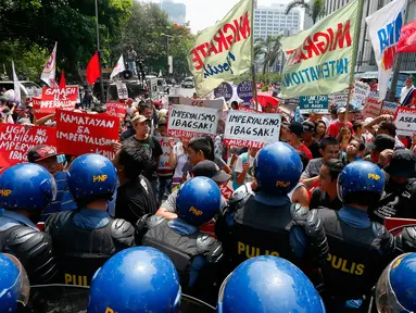 Sejumlah orang menggelar aksi protes di depan Kedutaan Besar AS di Manila, Jumat (28/4). Demonstran memprotes dugaan penguasaan oleh Amerika Serikat, Jepang dan China atas Asia Tenggara. (AP Photo / Bullit Marquez)