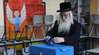 Pria Yahudi ultra-Ortodoks memasukan surat suaranya selama pemilihan parlemen Israel di Yerusalem (9/4). Warga Israel hari ini memberikan suara dalam pemilihan tingkat tinggi yang akan memutuskan masa jabatan PM Benjamin Netanyahu meskipun ada dugaan korupsi yang dilakukannya. (AFP Photo/Menahem Kah
