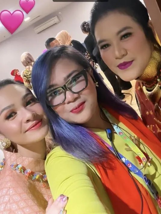 Kahiyang mengaplikasikan riasan galm, dengan lipstik merah matte dan blush on pink. Dengan gaya rambut ikat ke belakang. [@melahyarlyfe]