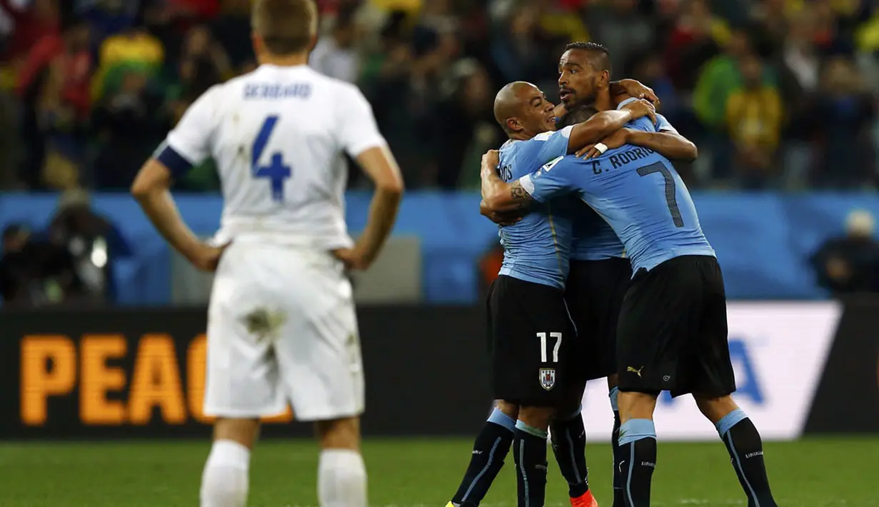 Kapten Timnas Inggris, Steven Gerrard (kiri) menyaksikan selebrasi pemain Uruguay saat berlaga di babak penyisihan Piala Dunia 2014 Grup D di Stadion Corinthians, Sao Paulo, Brasil, (20/6/2014). (REUTERS/Ivan Alvarado)