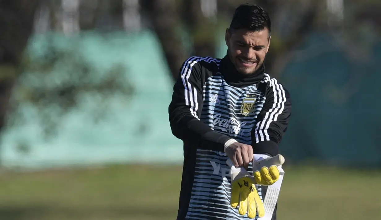 Kiper Argentina Sergio Romero memakai sarung tangan sebelum latihan di Ezeiza, Buenos Aires, (22/5). Untuk menggantikan Romero, Argentina memanggil kiper Tigres UANL, Nauel Guzman. (AFP Photo/Juan Mabromata)