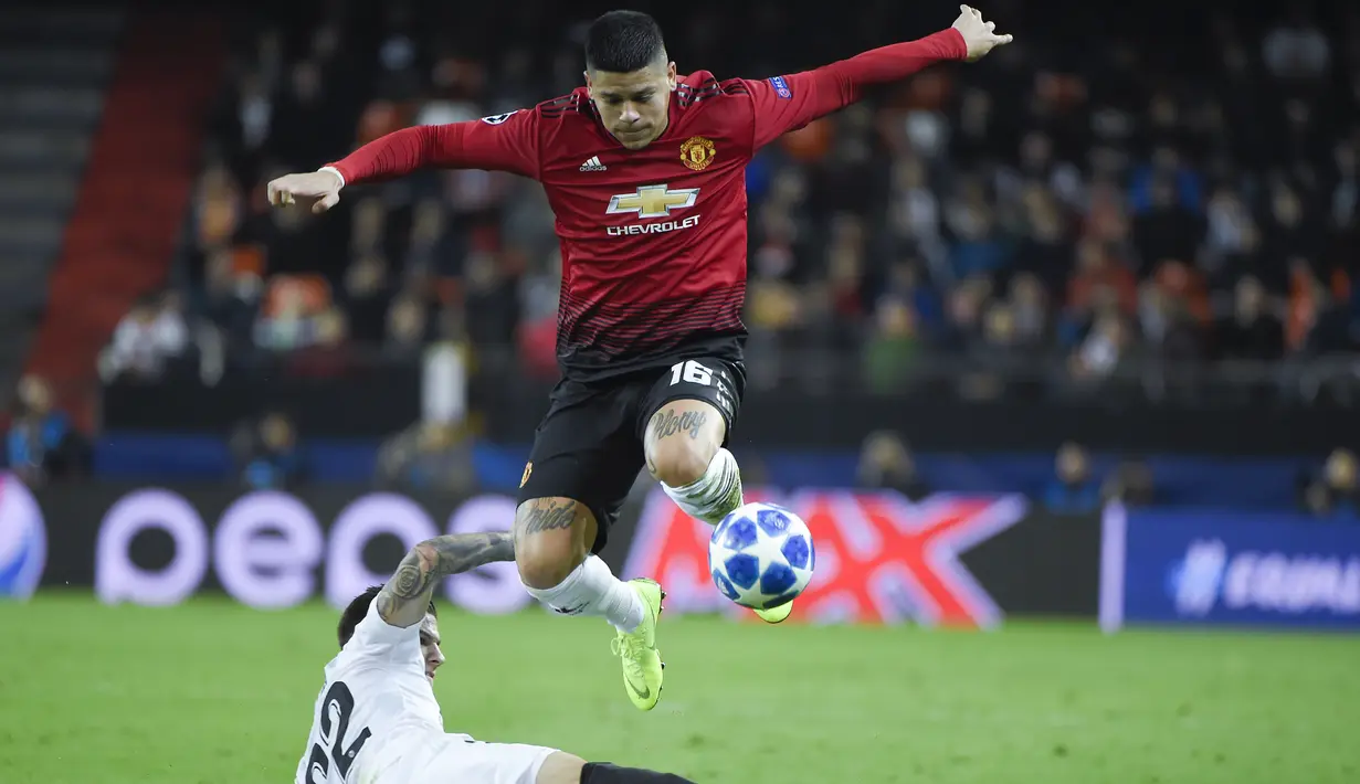 Aksi Marcos Rojo melompat dari terjangan Santi Mina pada laga terakhir grup H Liga Champions yang berlangsung di stadion Mestalla, Valencia, Rabu (13/12). Manchester United kalah 1-2 atas Valencia. (AFP/Jose Jordan)