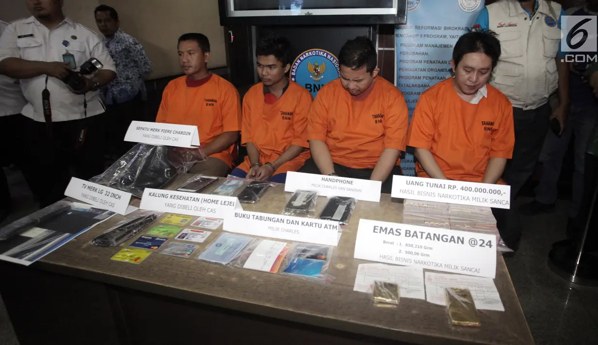 Tersangka beserta barang bukti dalam rilis kasus tindak pidana pencucian uang (TPPU) di Kantor BNN, Jakarta, Rabu (17/1). Petugas mengamankan barang bukti yaitu emas batangan 500 gram dan 850 gram dan uang tunai Rp400 juta. (Liputan6.com/Arya Manggala)