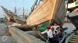 Sejumlah warga berangkat menggunakan perahu untuk salat Idul Fitri di Pelabuhan Sunda Kelapa, Jakarta, Rabu (6/7). Umat muslim seluruh dunia merayakan Lebaran 1437 H setelah melaksanakan ibadah puasa selama satu bulan. (Liputan6.com/Johan Tallo)