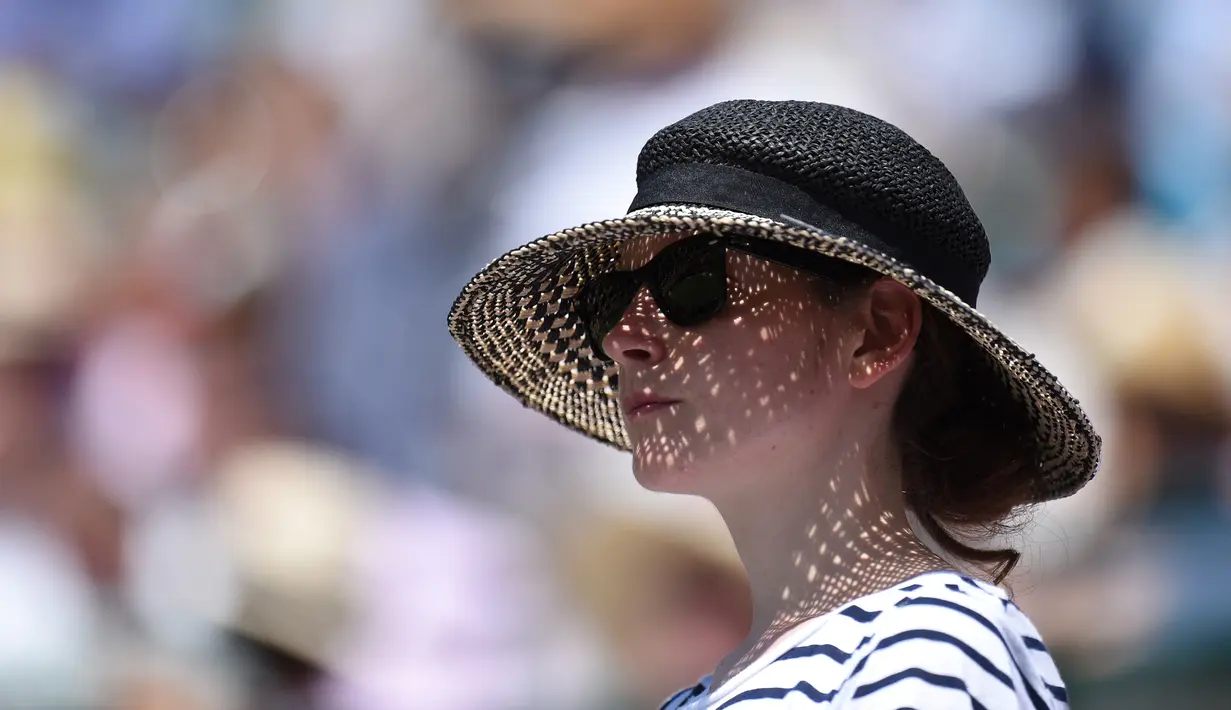Seorang fans wanita mengenakan topi menyaksikan pertandingan Kei Nishikori dari Jepang melawan petenis Ukraina Sergiy Stakhovsky di Kejuaraan Wimbledon 2017 di The All England Lawn Tennis Club di Wimbledon, London, Inggris (5/7). (AFP Photo/Olif Scarff)