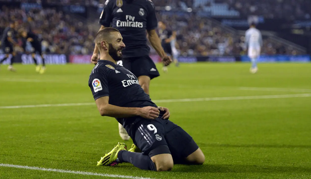Selebrasi penyerang Real Madrid, karim benzema usai menciptakan gol pertama bagi Real Madrid pada laga lanjutan pekan ke-12 La Liga 2018/19, Senin (12/11) yang berlangsung di stadion Balaidos, Spanyol. Celta Vigo tumbang 2-4. (AFP/Miguel Riopa)