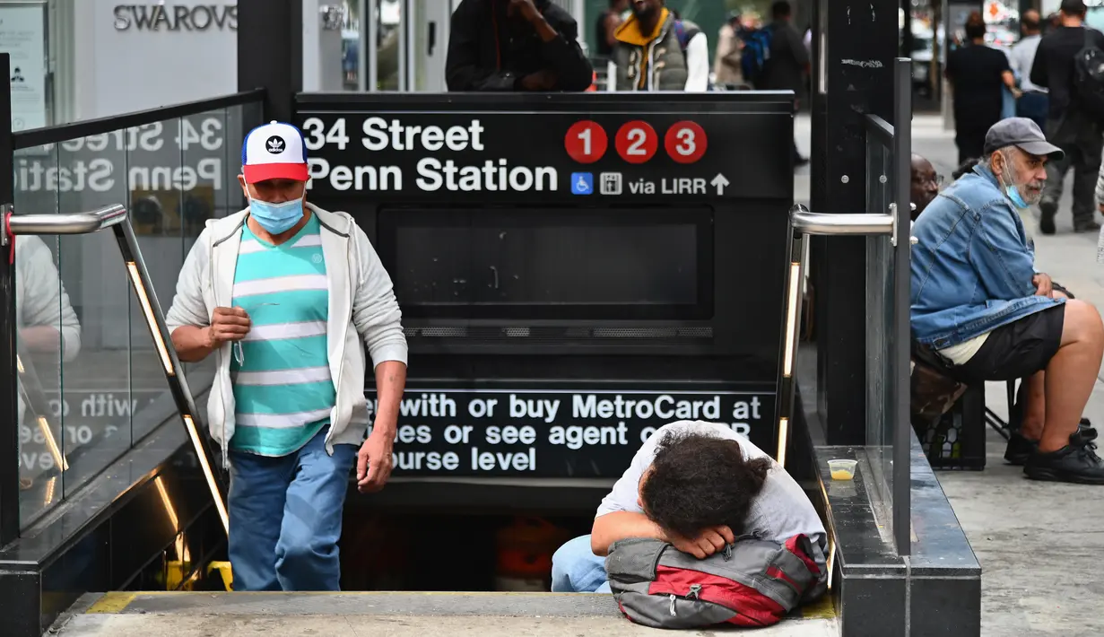 Seseorang tidur di tangga kereta bawah tanah dekat Penn Station di New York City pada Kamis (17/9/2020). Sejak pandemi virus corona, para tunawisma kini lebih terlihat seiring banyaknya penutupan banyak tempat penampungan karena alasan kesehatan. (Angela Weiss / AFP)