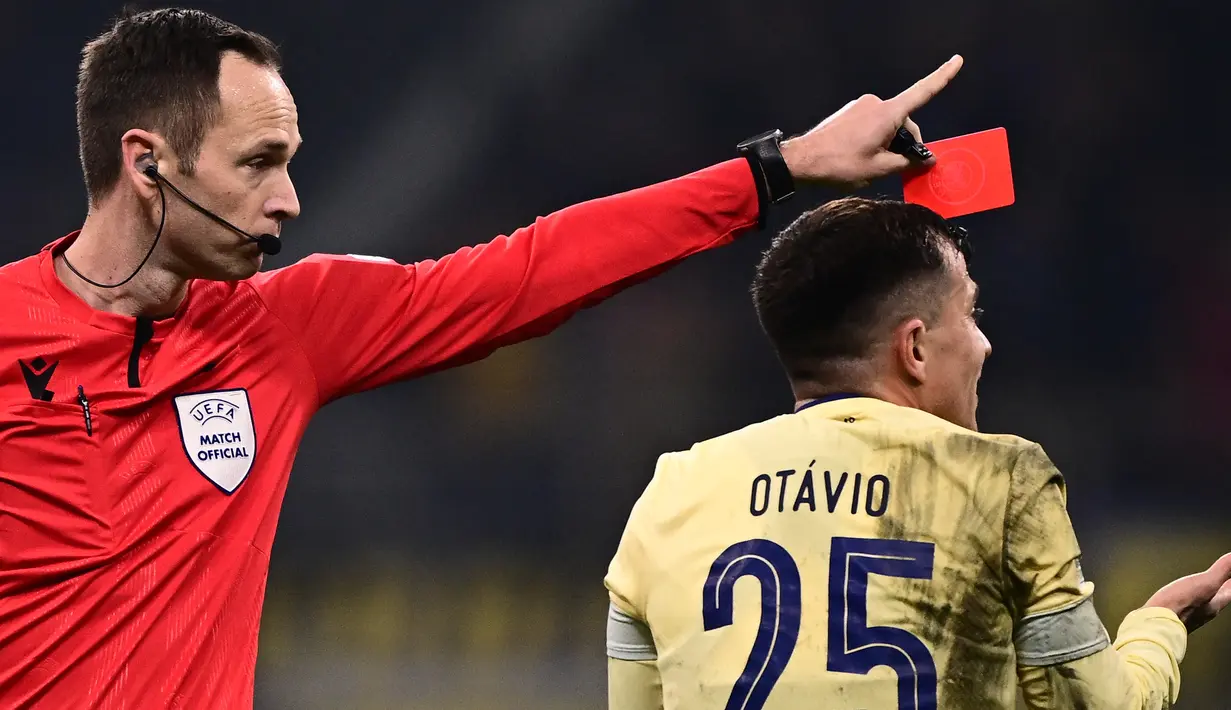 Wasit Srdjan Jovanovic (kiri) memberikan kartu merah kepada pemain FC Porto, Otavio da Silva dalam pertandingan leg pertama babak 16 besar Liga Champions 2022/2023 yang berlangsung di San Siro, Milan, Kamis (23/2/2023) WIB. (AFP/Marco Bertorello)