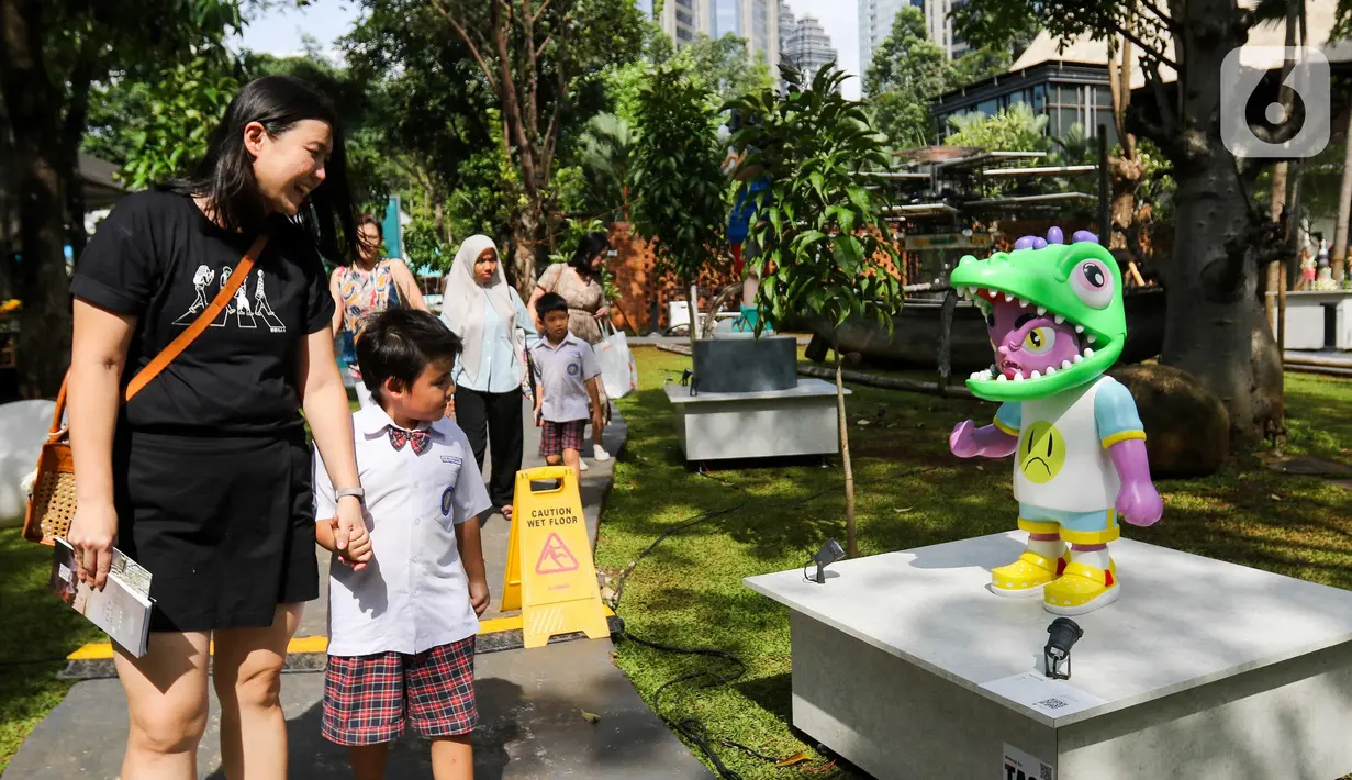 Pengunjung melihat-lihat karya seni instalasi pada pameran Art Jakarta Gardens di Hutan Kota Plataran, Senayan, Jakarta, Rabu (23/4/2025). (Liputan6.com/Herman Zakharia)