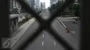 Sebuah taksi melintasi jalan protokol yang lengang di kawasan MH Thamrin, Jakarta, Selasa (6/7). Hampir semua jalan di Ibu Kota lengang saat sebagian besar warga mudik untuk merayakan Lebaran di kampung halaman. (Liputan6.com/Faizal Fanani)