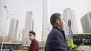 <p>Para komuter yang mengenakan masker berjalan saat badai debu dan pasir di kawasan pusat bisnis di Ibu Kota Beijing, China, Selasa (11/4/2023). Serangkaian badai debu dan pasir terbaru membuat indeks kualitas udara memburuk di Beijing pada Senin malam hingga Selasa. (AP Photo/Mark Schiefelbein)</p>