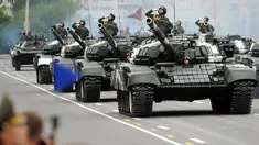 Tentara Belarus memberi hormat saat mengendarai tank dalam sebuah parade militer menandai Hari Kemerdekaan di Minsk (3/7). (AFP Photo/Sergie Gapon)