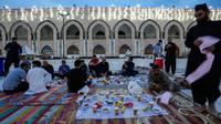Mereka menyantap makanan dan minuman yang dihidangkan di depan mereka. (AP Photo/Hadi Mizban)