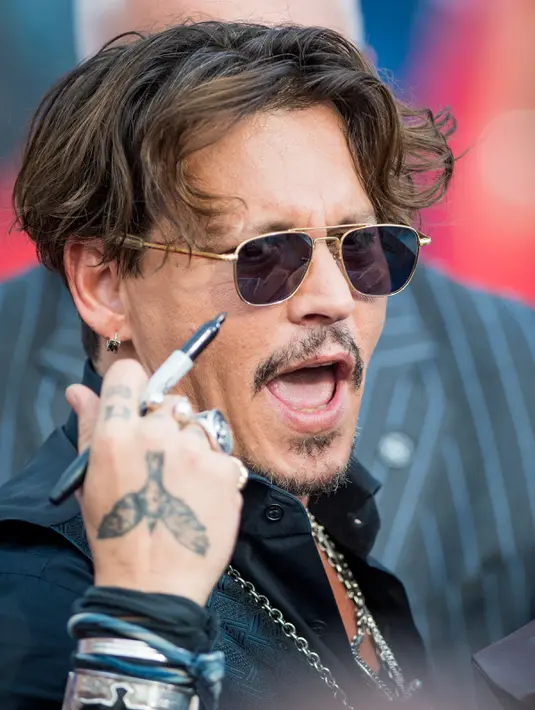 Ekspresi Johnny Depp saat menghadiri pemutaran perdana film Disney "Pirates of the Caribbean: Dead Men Tell No Tales" di Shanghai (11/5). (AFP Photo/Johannes Eiselle) 