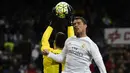 Penyerang Real Madrid, Cristiano Ronaldo, duel udara dengan kiper Sevilla, Sergio Rico, pada laga La Liga Spanyol di Stadion Santiago Bernabeu, Madrid, Minggu (20/3/2016). Madrid berhasil nanang 4-0 atas Sevilla. (AFP/Pierre-Philippe Marcou)