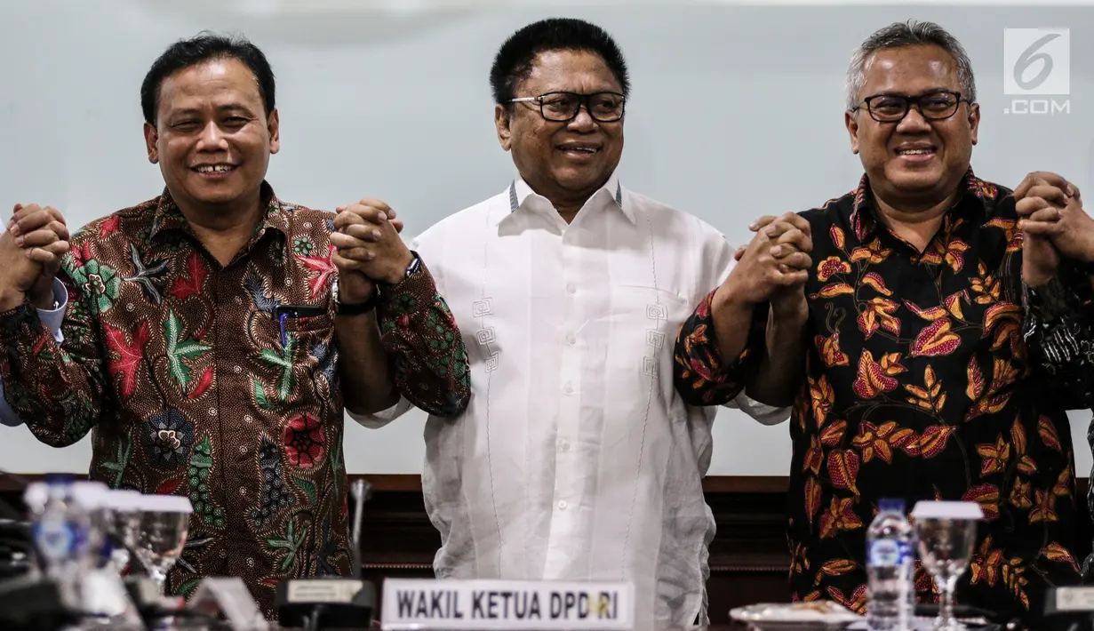 Ketua DPD Oesman Sapta Odang (tengah) bergandengan tangan dengan Ketua KPU RI Arief Budiman (kanan) dan Ketua Bawaslu Abhan (kiri) saat pertemuan DPD dengan KPU dan Bawaslu di Kompleks Parlemen, Senayan, Jakarta, Selasa (24/7). (Liputan6.com/Johan Tallo)