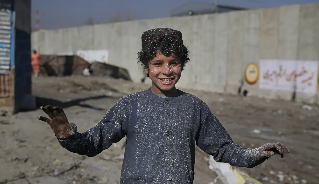 Seorang anak tersenyum di tempat pembuangan sampah di Kabul, Afghanistan (15/12/2019). Menurut statistik PBB, Afghanistan adalah salah satu negara termiskin di dunia di mana anak-anak menjadi sasaran kemiskinan dan kekerasan ekstrem setiap hari.  (AP Photo/Altaf Qadri)