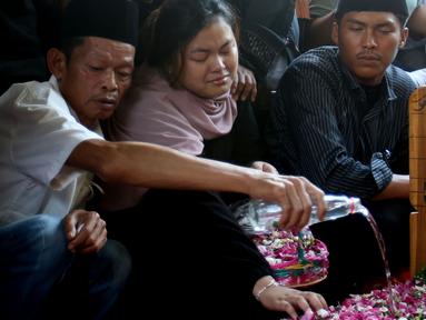 Kerabat menabur bunga di makam presenter sekaligus komedian Nina Carolina atau yang akrab dipanggil Mpok Alpa di Tempat Pemakaman Umum (TPU) Kujaran, Ciganjur, Jakarta Selatan pada Jumat (15/8/2025). (KapanLagi.com/Budy Santoso)