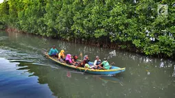 Perahu wisatawan melewati hutan mangrove di Sungai Rindu, Desa Hurip Jaya, Babelan, Bekasi, Jumat (7/6/2019). Berkeliling naik perahu melewati kawasan hutan mangrove di Sungai Rindu ini menjadi daya tarik para wisatawan lokal. (merdeka.com/Arie Basuki)