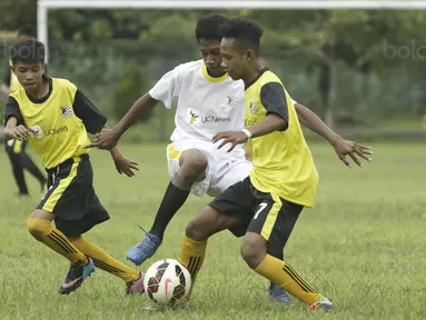 Pemain SSB Galunggung FC berusaha melewati kepungan pemain SSB Tulehu Putra pada semifinal turnamen Liga Remaja UC News di Lapangan Masariku Yonif 733, Ambon, Rabu (29/11/2017). (Bola.com/Peksi Cahyo)