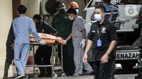 Tim forensik menurunkan kantong jenazah berisi serpihan Sriwijaya Air SJ 182 dan diduga tubuh korban dari ambulans di RS Polri, Jakarta, Minggu (10/1/2021). RS Polri menerima tiga kantong jenazah berisi serpihan pesawat dan diduga tubuh korban untuk diidentifikasi. (merdeka.com/Iqbal S. Nugroho)