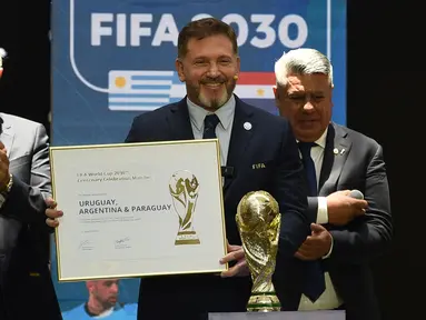 Presiden Paraguay, Alejandro Dominguez (tengah) memegang sertifikat yang mengesahkan Argentina, Paraguay, dan Uruguay sebagai negara tuan rumah Piala Dunia FIFA 2030 selama Kongres virtual FIFA di Luque, Paraguay pada 11 Desember 2024. (AFP/Daniel Duarte)