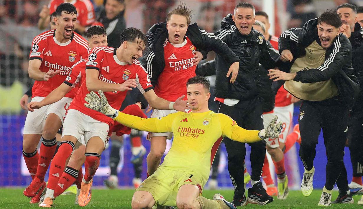Gol sundulan sang kiper pada menit ke-90+8 itu memastikan kemenangan Benfica atas Real Madrid. Tampak dalam foto, kiper Benfica asal Ukraina, Anatoliy Trubin (tengah) merayakan golnya selama pertandingan pekan ke-8 Liga Champions 2025-2026 melawan Real Madrid di Estadio da Luz, Lisbon, Rabu (28/1/2026) waktu setempat atau Kamis (29/1/2026) dini hari WIB. (PATRICIA DE MELO MOREIRA/AFP)