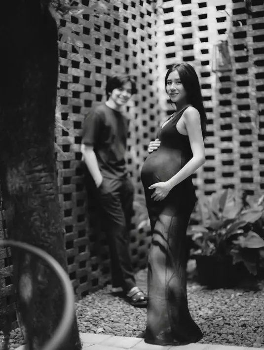 Ia pancarkan aura keibuan yang khas di balik balutan sheer dress panjang bernuansa hitam [@angga]